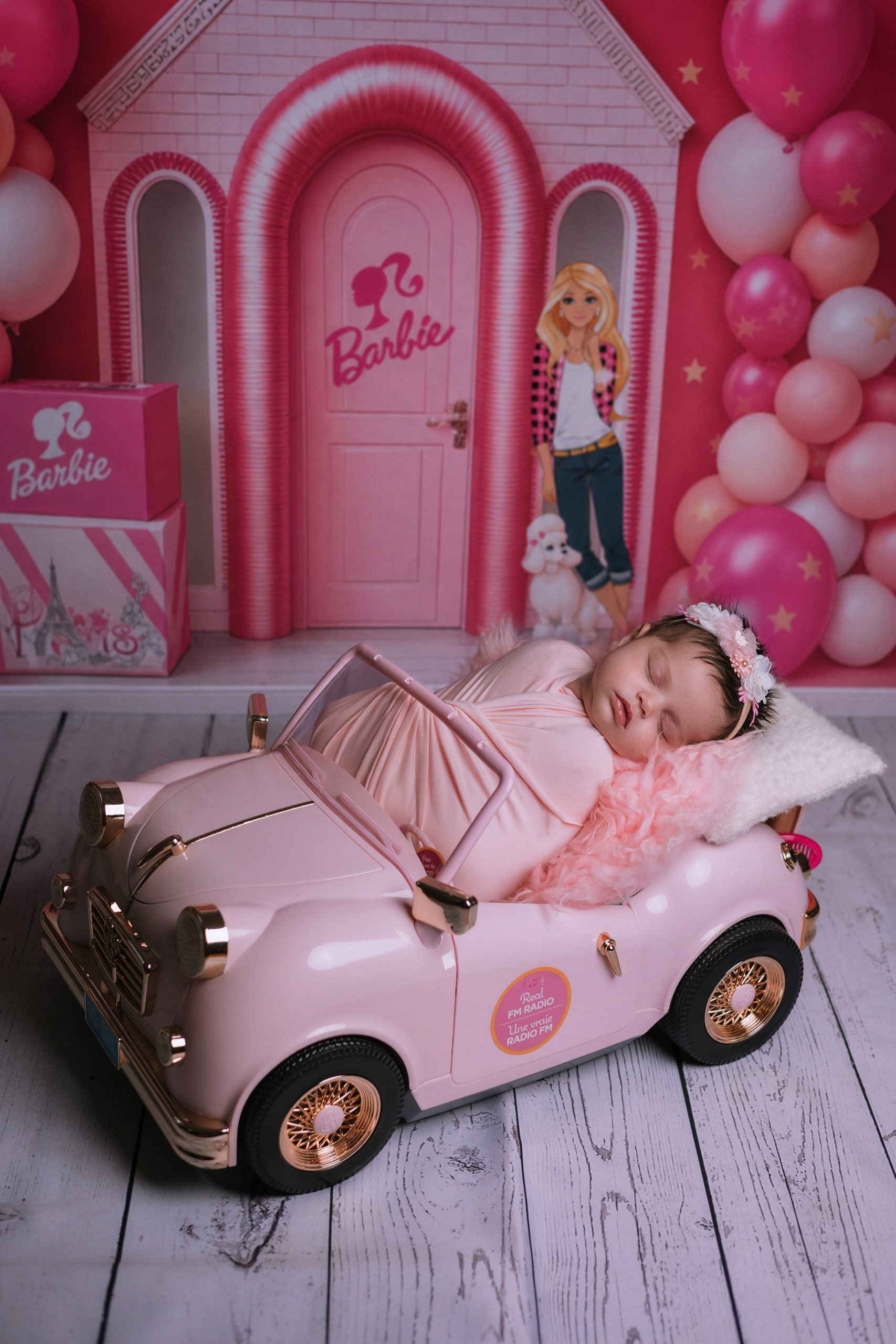 Baby in a playful pink miniature car setup